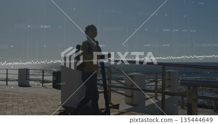 Riding child wearing yellow sweater jeans on scooter along coast, with backpack headphones overlay 135444649