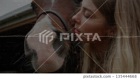 Nuzzling woman leaning toward horse muzzle in stable with wood beams, black halter, digital overlay Nuzzling woman leaning toward horse muzzle in stable with wood beams, black halter, digital overlay 135444668
