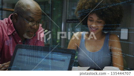 Collaborating mentor and mentee reviewing code at glass meeting room, with laptop and coffee cup 135444707