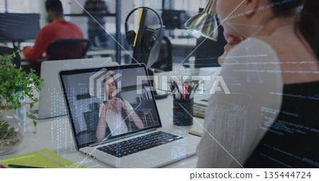 Attending virtual meeting, woman wearing light sweater typing on laptop at office desk, copy space 135444724