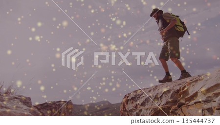 Stepping hiker crossing rugged mountain outcrops, with bucket hat backpack boots, copy space 135444737