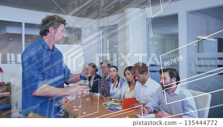 Gesturing man wearing blue shirt addressing coworkers in conference room with overlays, copy space Gesturing man wearing blue shirt addressing coworkers in conference room with overlays, copy space 135444772