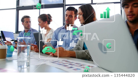 Team wearing business casual analyzing data in meeting room, with laptops, charts, digital icons 135444820