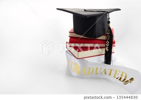 Graduation cap, books, and 2026 sash representing academic achievement 135444830