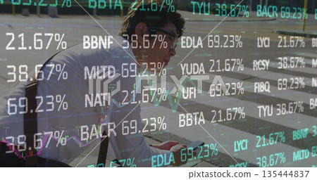 Pausing Asian man wearing eyeglasses, with satchel on crosswalk, checking phone with stock overlays 135444837