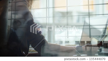 Typing employee in blazer on laptop at wooden desk in office, with window blinds, copy space Typing employee in blazer on laptop at wooden desk in office, with window blinds, copy space 135444870