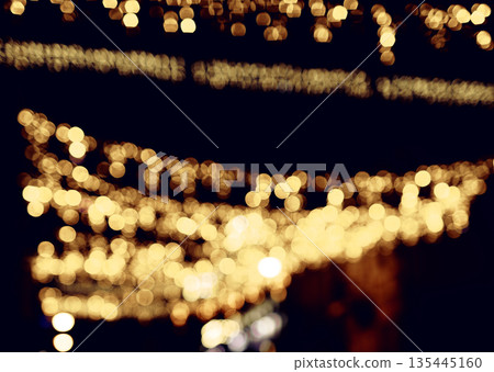 Bokeh lights glowing at night. Golden shimmer with blurred sparkle dots creating dreamy brilliance, 135445160