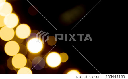 Bokeh lights in night blur. Golden yellow glow with dazzling sparkle, dreamy atmosphere, luminous 135445163
