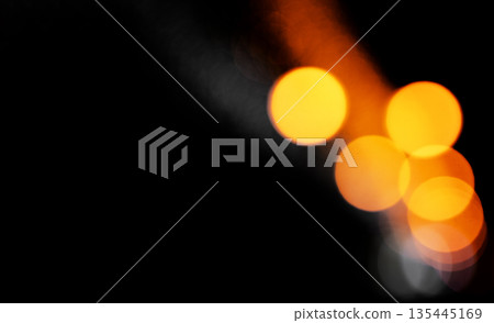 Bokeh lights in night. Large golden orange circles glow with brilliance on dark background leaving Bokeh lights in night. Large golden orange circles glow with brilliance on dark background leaving 135445169