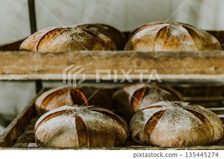 Baking bread. Dough in proofing basket on wooden table with flour, cumin and wheat ears. Top view. Baking bread. Dough in proofing basket on wooden table with flour, cumin and wheat ears. Top view. 135445274