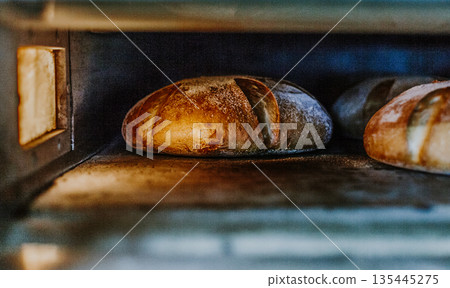 Fresh buns from the oven. Conveyor with bread. Baking bread. Workshop for production of bread. White bread in the oven. Hot buns. Confectionery. Fresh buns from the oven. Conveyor with bread. Baking bread. Workshop for production of bread. White bread in the oven. Hot buns. Confectionery. 135445275