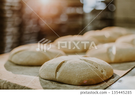 Dessert bread baking in oven. Production oven at the bakery. Baking bread. Manufacture of bread. 135445285