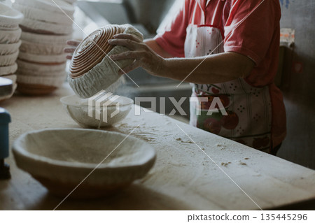 Women bake pies. Confectioners make desserts. Making buns. Dough on the table. 135445296