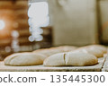Dessert bread baking in oven. Production oven at the bakery. Baking bread. Manufacture of bread. 135445300