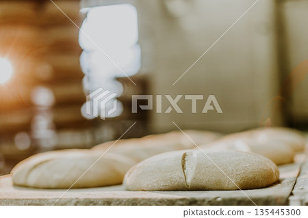 Dessert bread baking in oven. Production oven at the bakery. Baking bread. Manufacture of bread. Dessert bread baking in oven. Production oven at the bakery. Baking bread. Manufacture of bread. 135445300