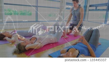 Three women in sportswear performing abdominal crunches on mats in studio, with instructor whistle Three women in sportswear performing abdominal crunches on mats in studio, with instructor whistle 135445337