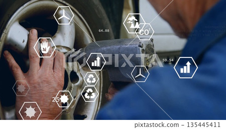 Turning coverall mechanic tightening lug nuts using wrench on wheel in garage with digital icons 135445411