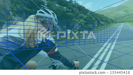 Riding female cyclist on road bicycle on winding mountain road with double white lines, copy space 135445418