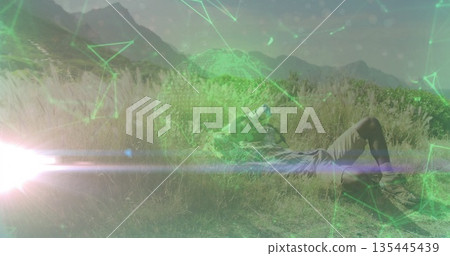 Lying hiker using binoculars in grassy meadow at mountain base with AR overlay, copy space Lying hiker using binoculars in grassy meadow at mountain base with AR overlay, copy space 135445439
