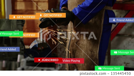 Grinding workpiece with angle grinder by worker in coveralls and apron in workshop, sparks flying Grinding workpiece with angle grinder by worker in coveralls and apron in workshop, sparks flying 135445450