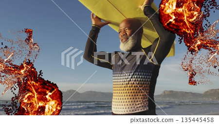Holding mature surfer lifting yellow surfboard at beach, with patterned top, neoprene pants Holding mature surfer lifting yellow surfboard at beach, with patterned top, neoprene pants 135445458