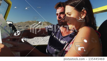 Consulting tourist couple spreading map in yellow convertible on sandy shore, with floating icons Consulting tourist couple spreading map in yellow convertible on sandy shore, with floating icons 135445469