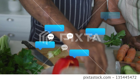 Chopping celery and slicing carrots couple cooking at kitchen counter, with chat bubbles 135445472