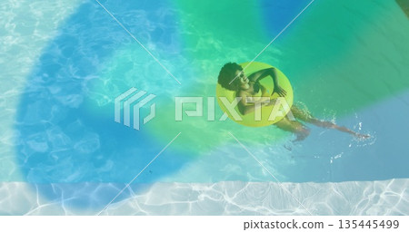Floating woman wearing yellow bikini and sunglasses in pool with yellow inflatable tube copy space Floating woman wearing yellow bikini and sunglasses in pool with yellow inflatable tube copy space 135445499