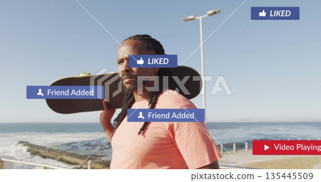Standing man wearing pink T-shirt holding skateboard on sea walkway, with rails, lamp post, icons 135445509