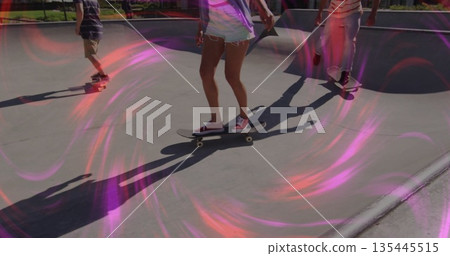 Riding woman wearing purple tank top balancing on skateboard at skate park bowl, with skateboards Riding woman wearing purple tank top balancing on skateboard at skate park bowl, with skateboards 135445515