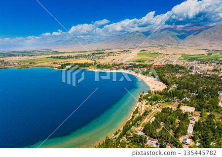 Scenic coastal landscape with blue water and mountains at Issyk-Kul lake 135445782