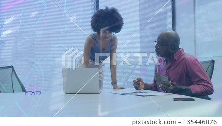 Reviewing documents and laptop screen, senior man and woman collaborating in office, with tablet Reviewing documents and laptop screen, senior man and woman collaborating in office, with tablet 135446076