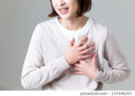 中年婦女摀著胸口痛苦不堪 中年婦女摀著胸口痛苦不堪 135446203