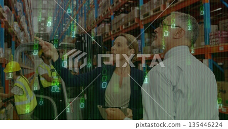Businesswoman pointing at stock and using tablet in warehouse with forklift pallet jack operating 135446224