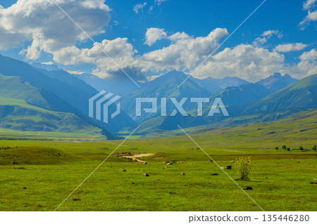 Majestic mountain landscape with rolling green hills and clouds in Kyrgyzstan Majestic mountain landscape with rolling green hills and clouds in Kyrgyzstan 135446280