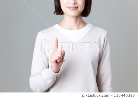 一位身著休閒服的中年婦女伸出食指 135446386