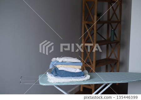 Home clothing care space with iron on ironing board ready for use showing organization and neat household routine 135446399