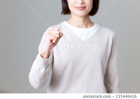 一位身著休閒裝的中年婦女揮舞拳頭 135446416