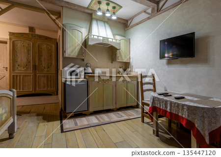 Rustic studio interior with green kitchenette and dining area 135447120