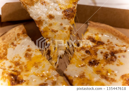Cheese pizza with melted cheese pulled from the box at a gathering Cheese pizza with melted cheese pulled from the box at a gathering 135447618