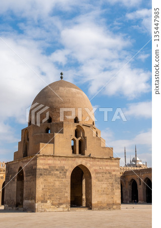 Ibn Tulun Mosque in Cairo features a large dome and intricate architectural details. The structure showcases Islamic design elements and historical significance. 135447985