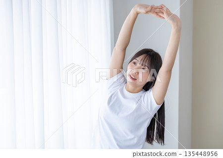 靠窗伸展的年輕女子 靠窗伸展的年輕女子 135448956