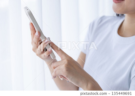 Young woman using a smartphone Young woman using a smartphone 135449691