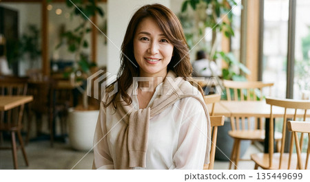 A woman in her 40s smiling and talking in a cafe A woman in her 40s smiling and talking in a cafe 135449699