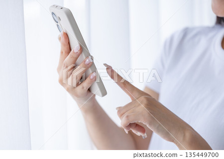 Young woman using a smartphone Young woman using a smartphone 135449700