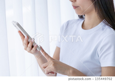 Young woman using a smartphone Young woman using a smartphone 135449702