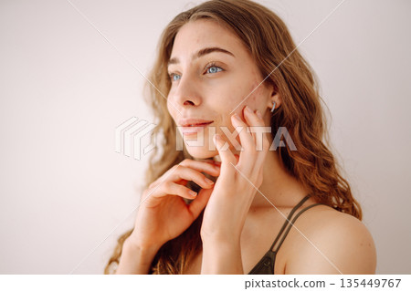 Portrait of a beautiful young woman with inflammations on the skin of her face. Acne disease. Portrait of a beautiful young woman with inflammations on the skin of her face. Acne disease. 135449767