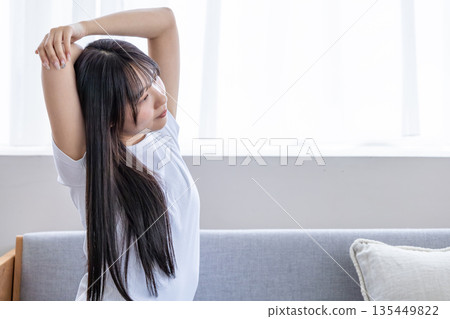Young woman stretching on the sofa Young woman stretching on the sofa 135449822