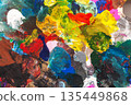 Close-up of thick multicolored paint. Textured strokes of blue, yellow, red, and green create a dynamic abstract texture. Concept of modern art, creative chaos, and painting 135449868