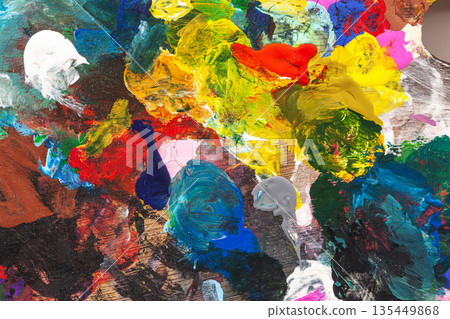 Close-up of thick multicolored paint. Textured strokes of blue, yellow, red, and green create a dynamic abstract texture. Concept of modern art, creative chaos, and painting 135449868
